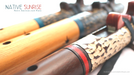 Spanish Cedar and Smoked Walnut Native American FLutes shown laying on a white blanket